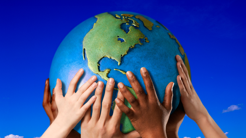 Multicultural hands holding up globe 